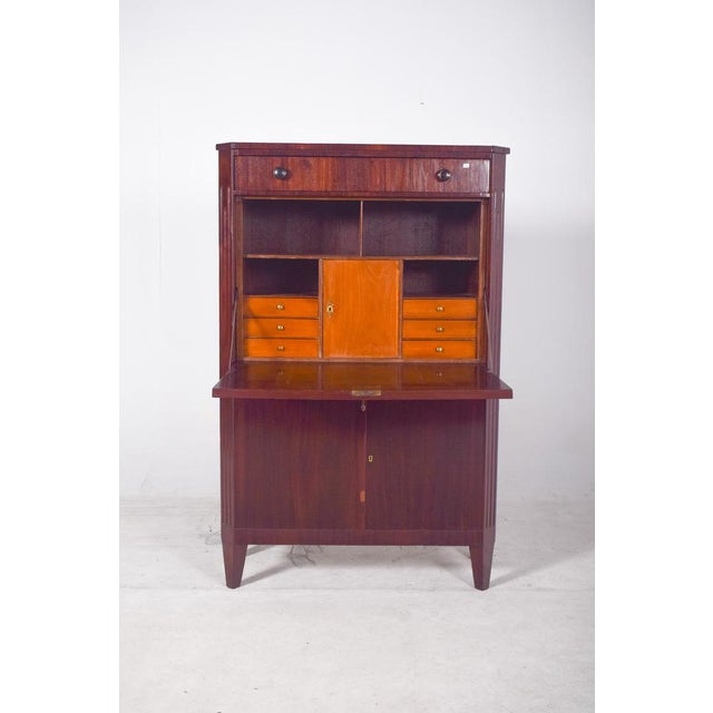 Abattant" desk. It has an austere, Biedermeier-inspired aesthetic, made from dark wood with a polished finish and a...