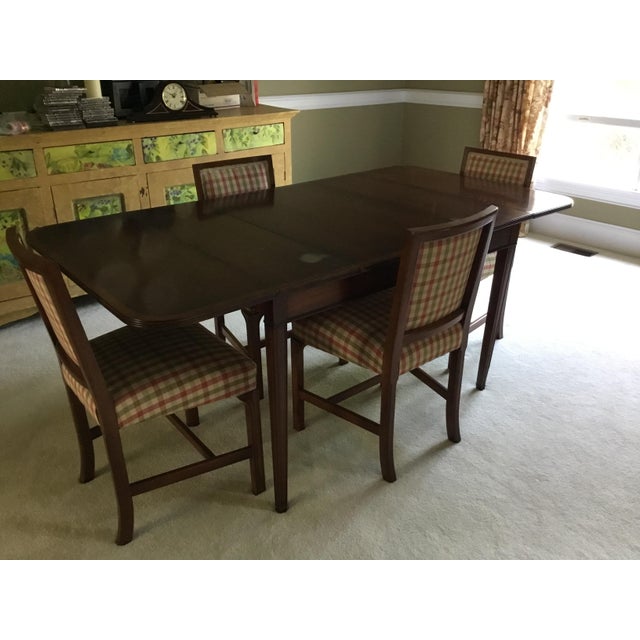 A beautifully crafted vintage dining set by Brandt Furniture, featuring a mahogany drop-leaf dining table, four matching...