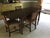 A beautifully crafted vintage dining set by Brandt Furniture, featuring a mahogany drop-leaf dining table, four matching...