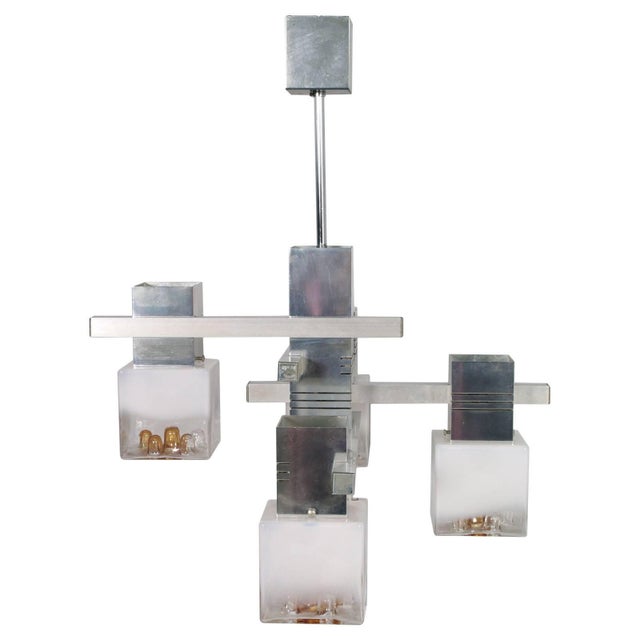 This aluminium framed chandelier features five cubic lights of Murano glass. This piece has an attribution mark, I am sure...