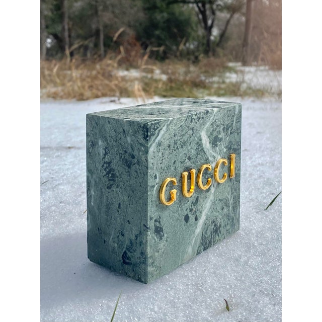 Minimalist green marble Gucci bookend. A carved monolithic rectangular form with surface mounted gold-plated metal letters...