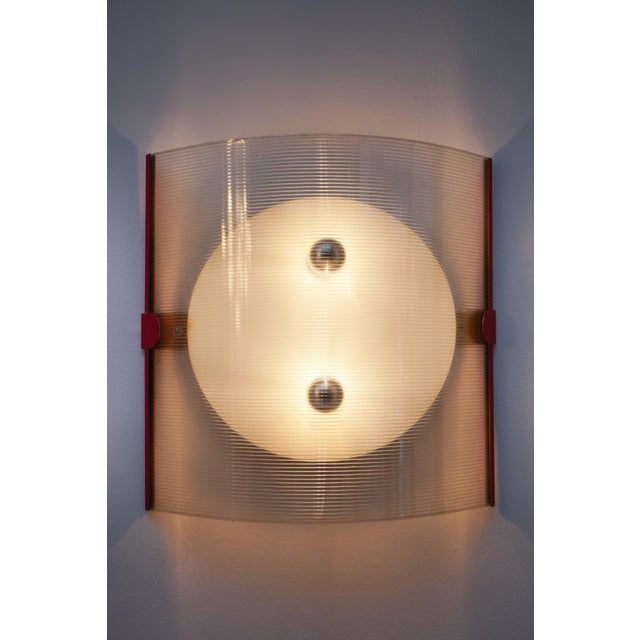 Wall lamp in red and white painted metal and polycarbonate. Large lamp with a strong visual impact. Soft light. European...