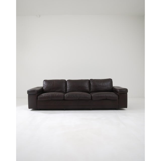 Made in Germany during the 20th century, this elegant three-seater sofa exudes classic appeal. The soft cushions, wrapped...