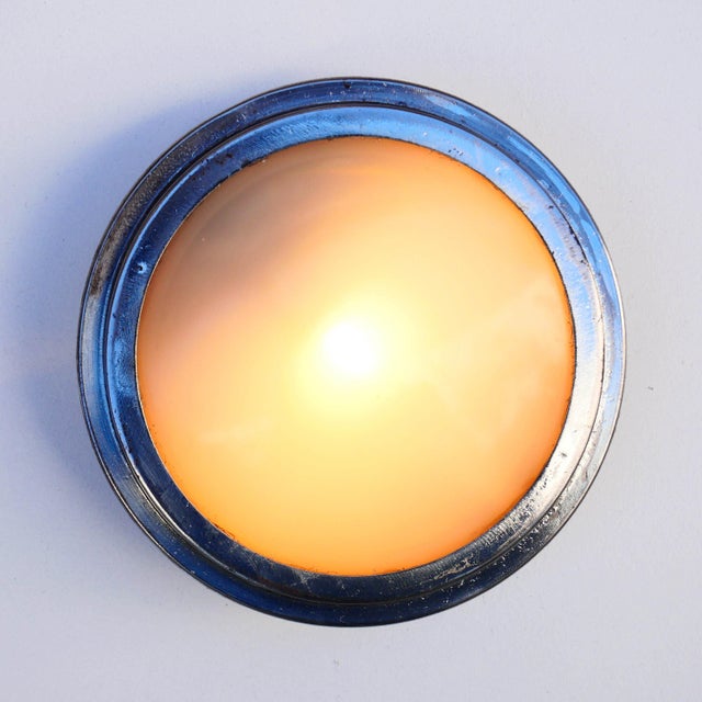 This vintage wall light in polished and varnished steel, with its porthole shape, brings a retro and industrial touch to...