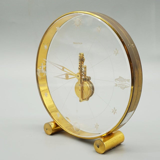 A mid-century zodiac mantel clock by jaeger lecoultre. Circular lucite case with original brass hands and inset zodiac...
