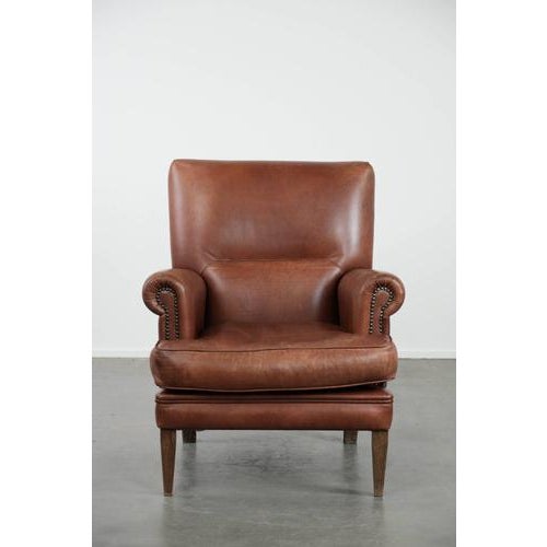 We are offering this attractive and comfortable armchair made of cognac-colored cowhide leather in English style. Thanks...