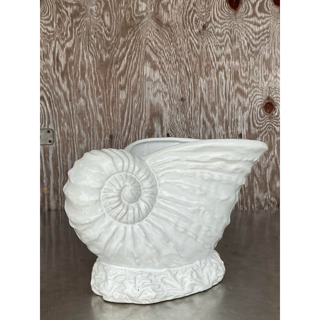 Bring a splash of coastal charm into your home with this striking Vintage Nautilus Shell Planter. Crafted in ceramic and...