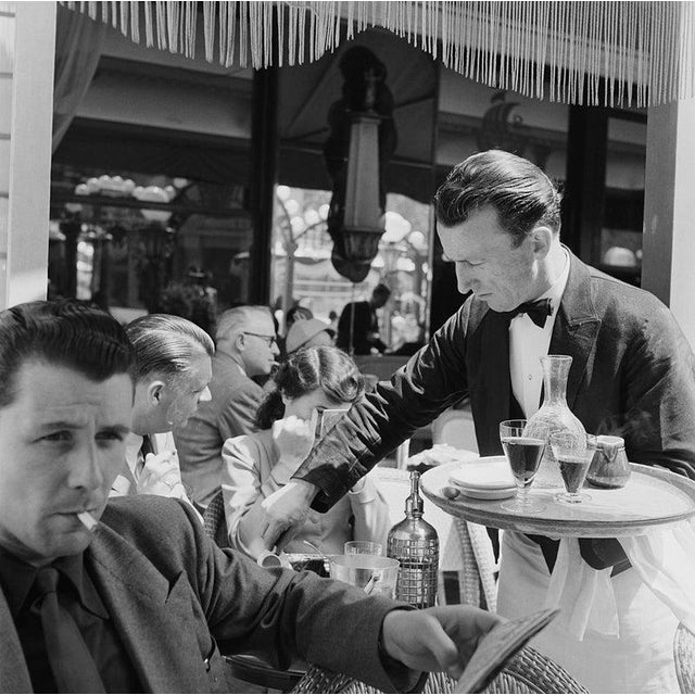 Cafe Culture A waiter serving clients on the terrace of a cafe on the Champs-Elysees, Paris, June 1951. Original...