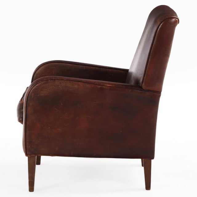 This warm chocolate brown chair is in very good condition and sits well with squared crest, slightly rolled arms and a...