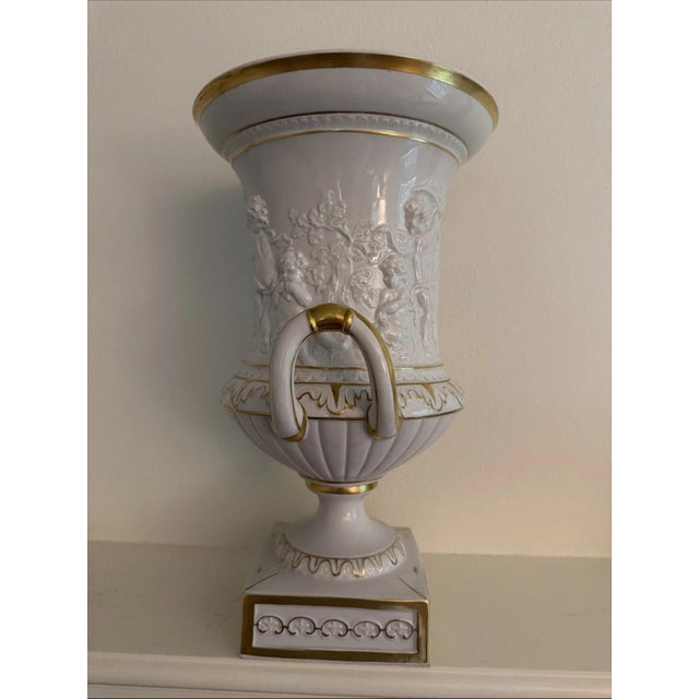 This Vintage Sandizell Hoffner White & Gold Large Urn with Cherubs is a decorative collectible piece that exudes elegance...