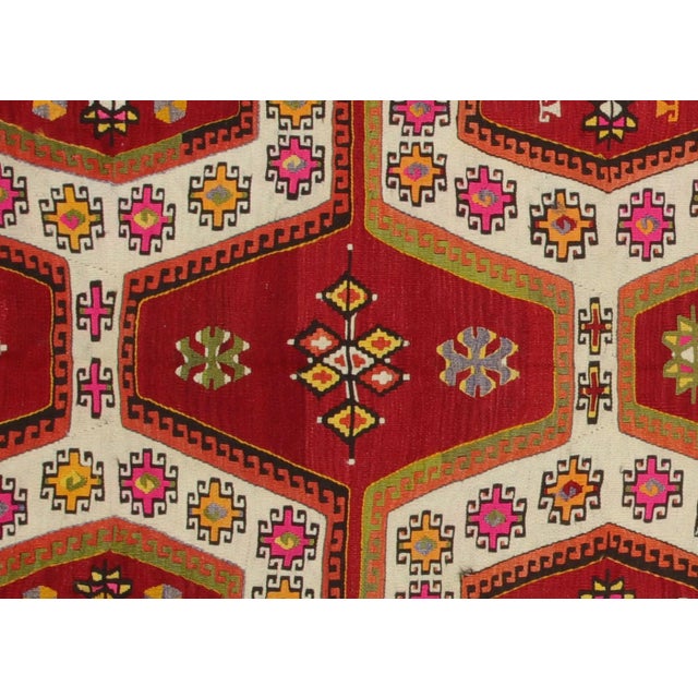 This vintage Turkish Kilim, measuring 5' by 11'3", is handwoven with wool on a wool foundation in the Oushak region of...