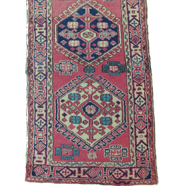 Burgundy field decorated with 11 geometric medallions. Wool pile on wool foundation. Hand knotted. Rare extra long.