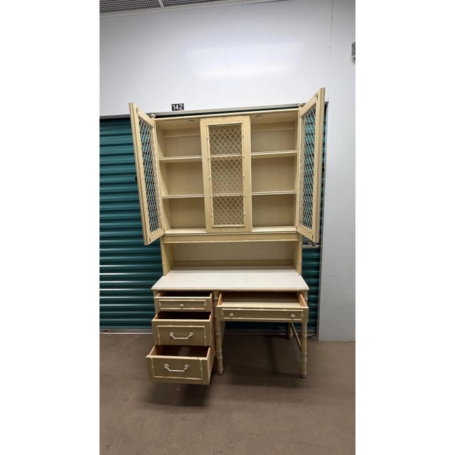This is a wonderful yellow and white Thomasville desk with a chicken wire hutch. The top has finials and palm leaf metal...