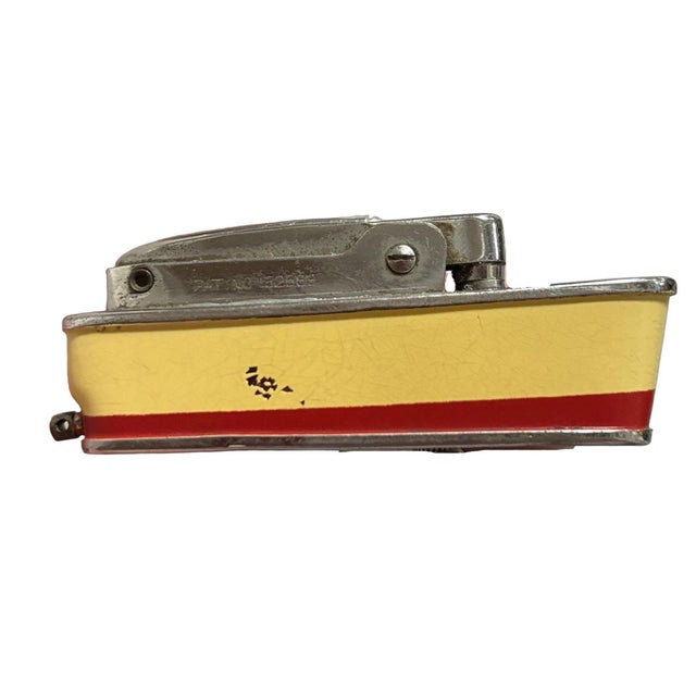 Mid-Century Sarome 'Cruiser' lighter, shaped like a Cruise ship, features a chrome body enameled red and yellow accents....