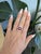 A dramatic star ruby cabochon glows deep red beneath a shimmering halo of diamonds, set in warm solid 14K rose gold. Its...