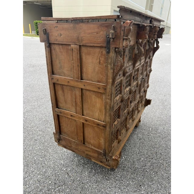An antique Indian carved wooden Damachiya dowry cabinet mounted on wheels from the 19th century with polychrome décor and...
