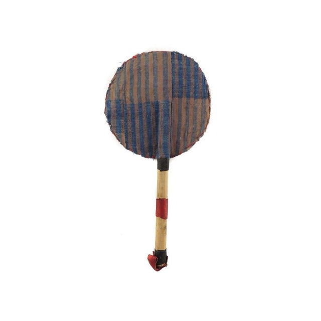 A beautiful beaded fan with colorful fabrics, cowrie shells and a wooden handle with a strap. In Yoruba culture, beads are...