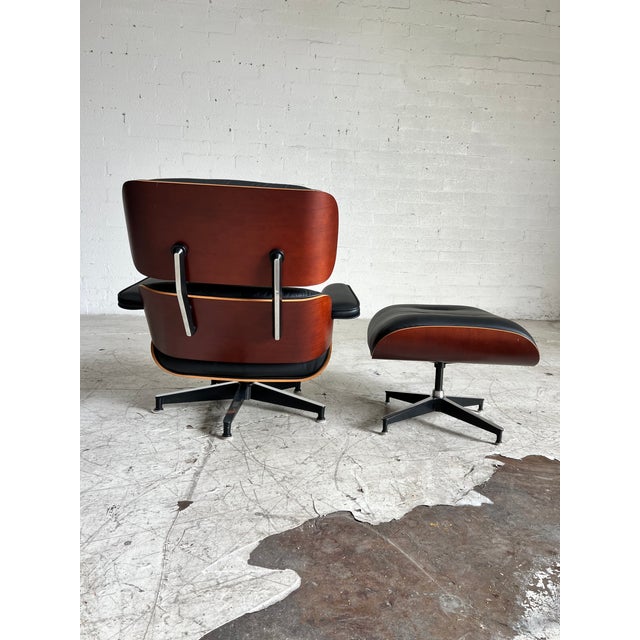 Mid-Century Modern Herman Miller Eames Chair and Ottoman, Black Leather and Cherry, 50th Anniversary Edition For Sale - Image 3 of 6
