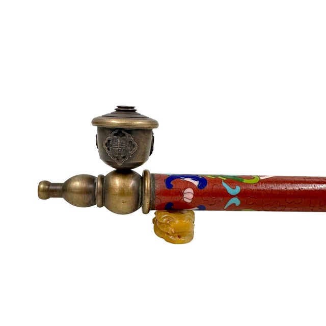 This Chinese Cloisonne smoking pipe features a long, slender stem decorated with colorful cloisonné enamel, a technique...