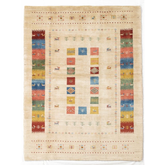Vintage Hand-knotted Persian Lori Gabbeh rug featuring a lively geometric composition set on a soft ivory field. The...