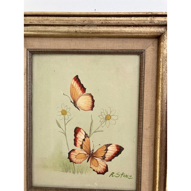 Description Vintage oil painting of two butterflies over small white flowers on a pale green ground. Signed R. Stone lower...