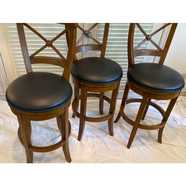 Classic swivel seat barstools black leather seat rounded backs with X pattern in mahogany