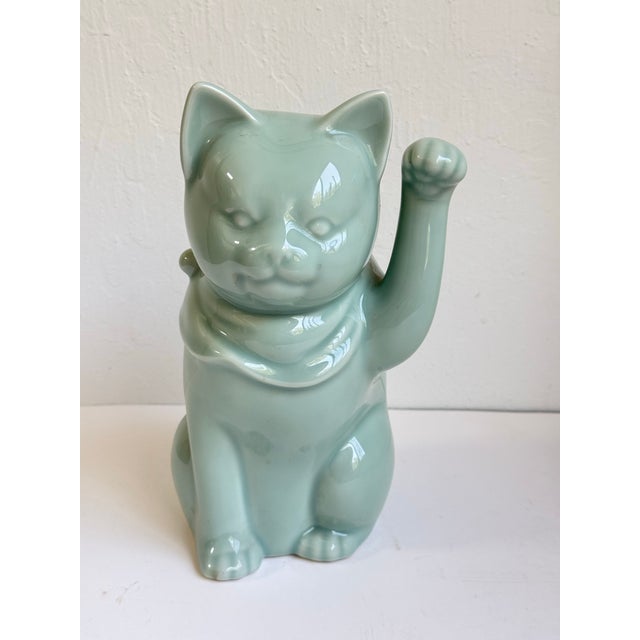 Whimsical vintage celadon glazed Maneki-neko lucky cat figurine featuring a soft seafoam green porcelain finish with a...