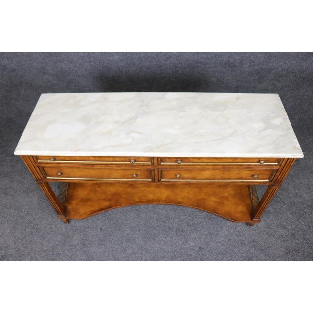 Elegant, timeless, and masterfully crafted, this exceptional French Louis XVI style marble-top console table beautifully...