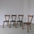 Set of four handcrafted dining chairs with a unique sculptural silhouette and turned wooden legs. Made from contrasting...