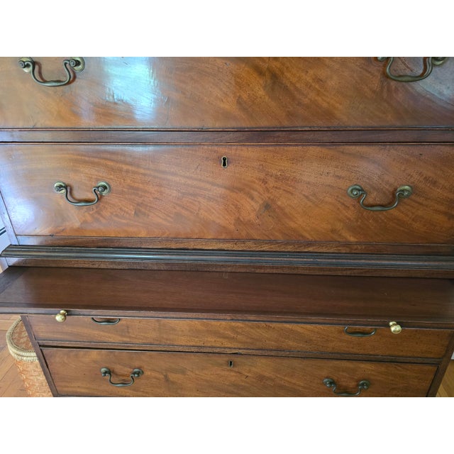 A distinguished Georgian-style mahogany chest-on-chest showcasing beautifully figured flame mahogany veneers, elegant...