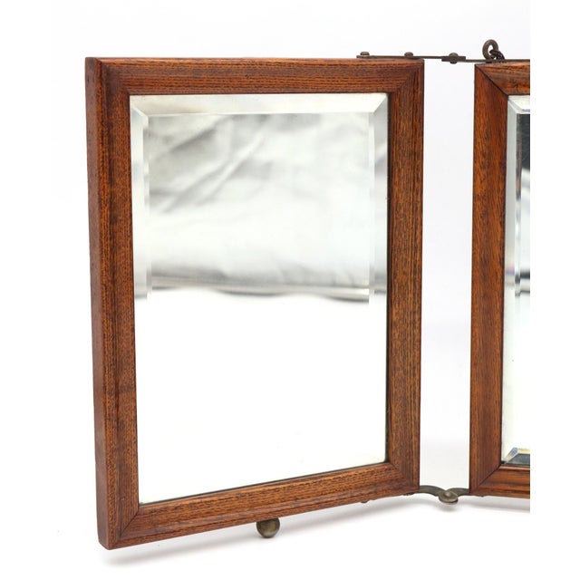 Vintage oak framed triple vanity mirror with bevel edges. The three rectangular mirrors are joined together by metal...