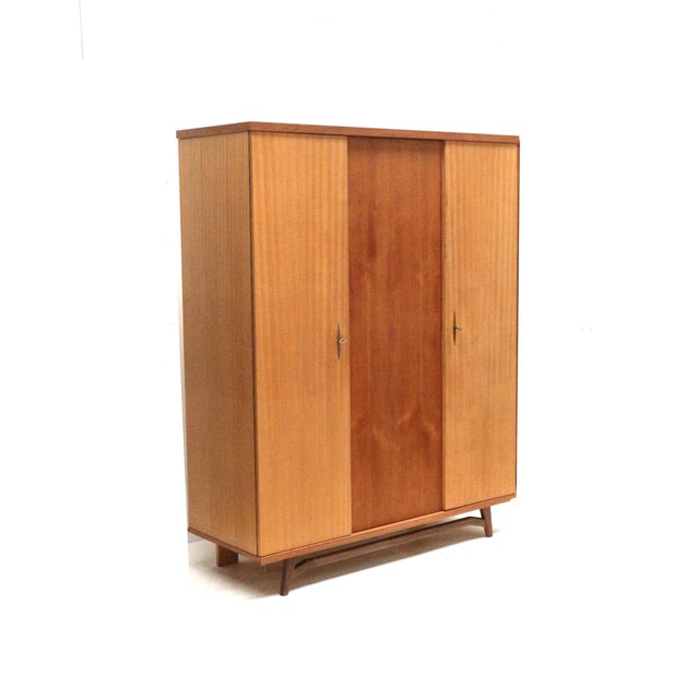 Vintage 3-door wardrobe/linen cupboard from the 1960s. Practical vintage 3-door wardrobe from the 1960s with a timeless...