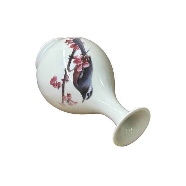 This elegant porcelain vase features a classic pear-shaped body that tapers into a slender neck and flares gracefully at...