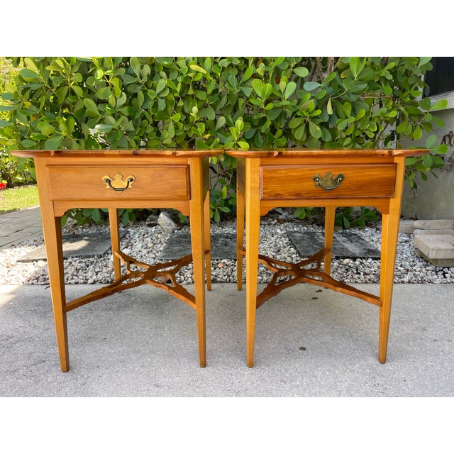 A charming pair of vintage pine side tables by Robb & Stucky featuring beautifully shaped scalloped tops, warm honey-toned...