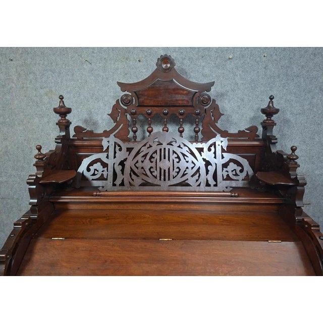 A rare, richly ornamented carved walnut harmonium in the neo-gothic and troubadour style of the late 19th century. This...