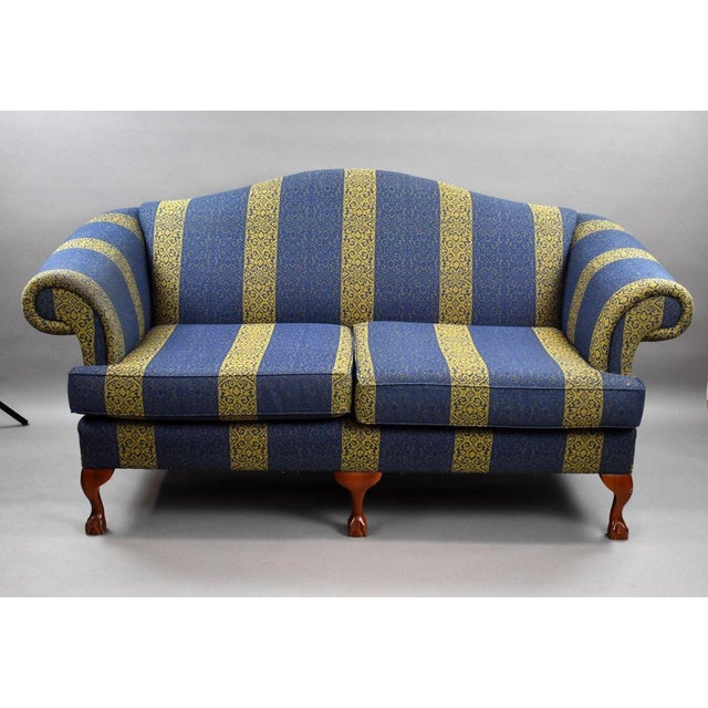 A handsome matched pair of upholstered sofas, featuring a timeless blue and gold striped damask fabric. Each sofa...