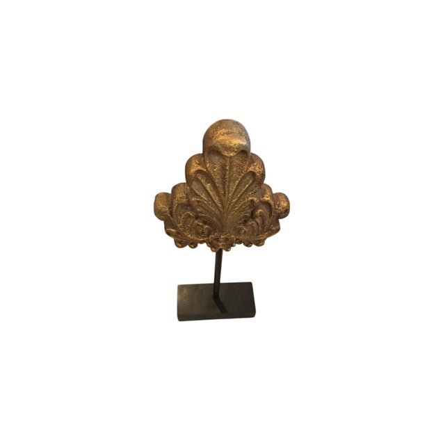 A striking decorative sculpture featuring an antique-style architectural fragment mounted on a minimalist black iron...