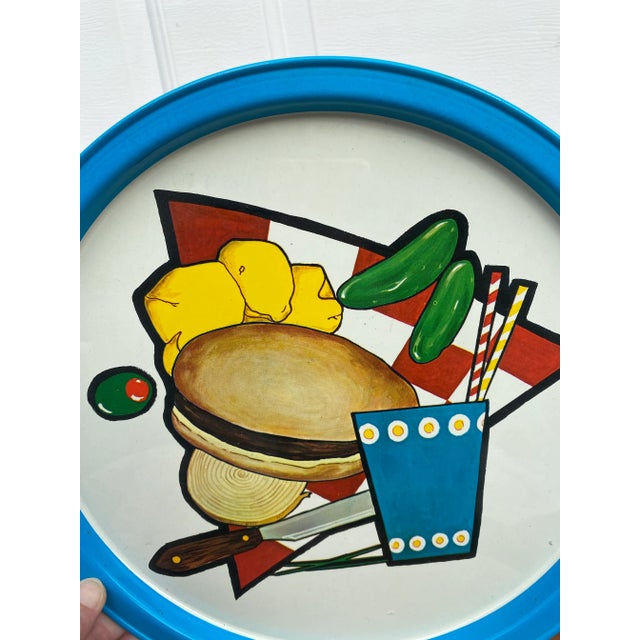 A round vintage metal tray featuring all your summertime grill-out favorites – hamburger, chips, soda, and pickles &...