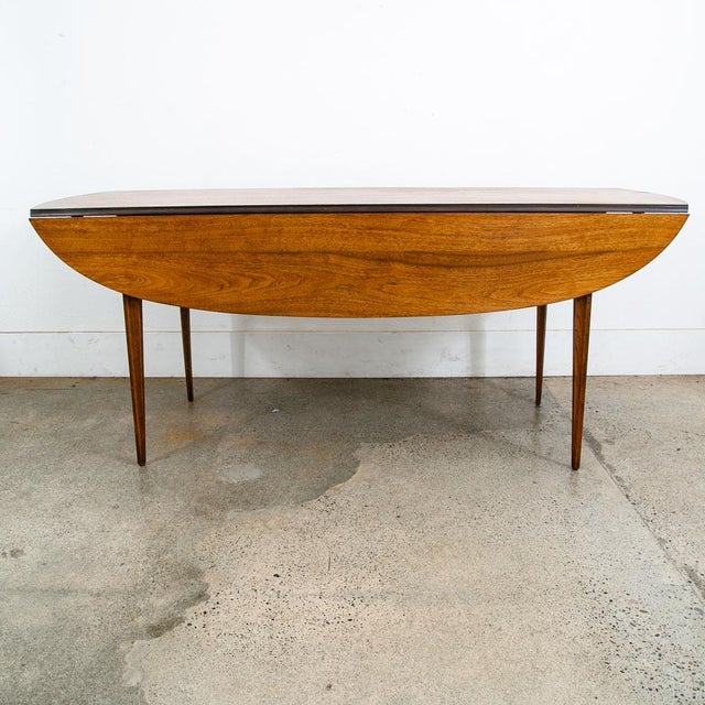 Fantastic and unique American walnut drop leaf dining table by Broyhill for the Brasilia line. Made Circa 1968. Table has...