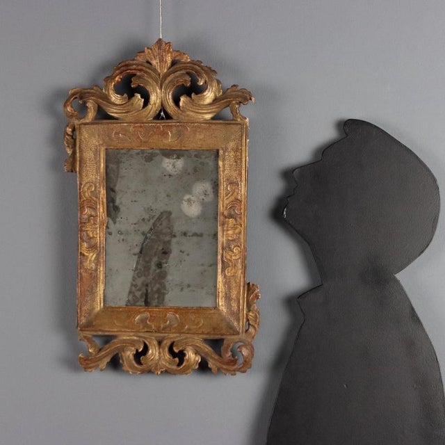 Small Baroque mirror made of a single piece of carved and gilded wood. The frame is stamped with bas-relief leaf carvings,...