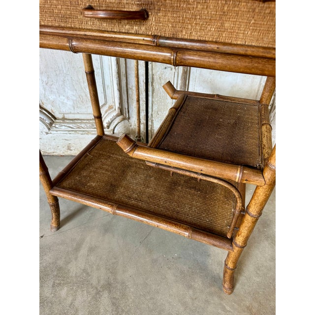 Small faux bamboo style table, circa 1900. Good overall condition, some wear to the tabletops. The apron opens to reveal a...