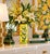 A vintage, hand-painted ceramic hat stand or vase, decorated with a yellow background, greenery and flowers. Good condition.
