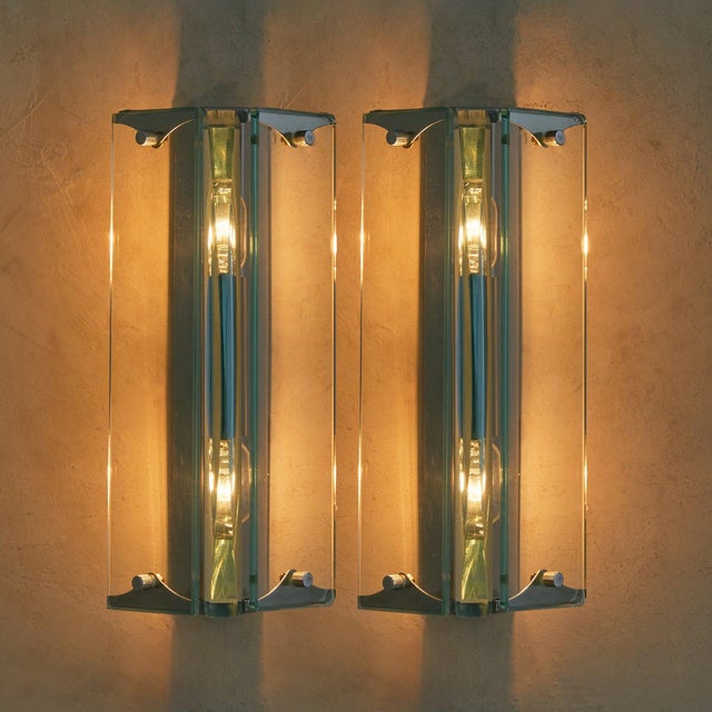 A pair of 1960s Italian sconces crafted in the manner of Fontana Arte, defined by their architectural chrome fittings and...