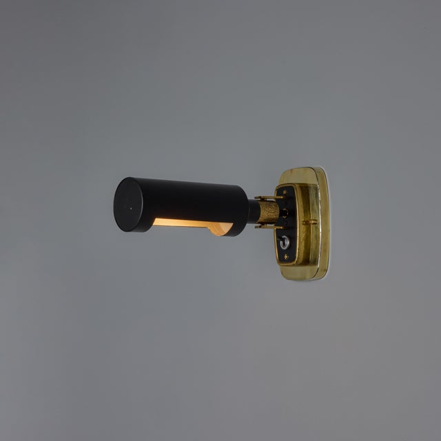 1960s Stilnovo Model #2134 Articulating Brass and Metal Wall Lamps Executed in black painted metal shade with brass...