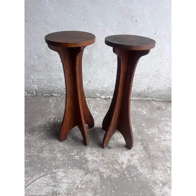A sculptural pair of French wooden pedestal stands dating from the early 20th century. Each piece features a circular top...