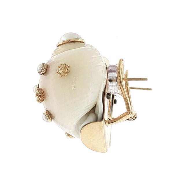 A pair of 14k gold earrings featuring natural seashells and round white cultured pearls. The design includes intricate...