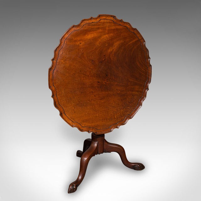 This is an antique silver display table. An English, mahogany tilt-top occasional table, dating to the Georgian period,...