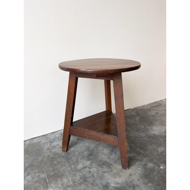 This antique late 19th-century Welsh cricket table features a classic circular top, showcasing a rich, aged scumble-...
