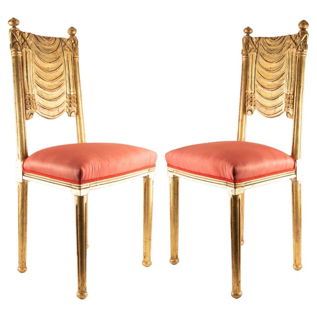 Pair of French Art Deco giltwood side chairs, circa 1930s, featuring elegantly carved backs with stylized draped swag...