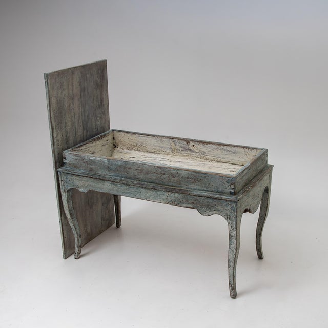 Blue-painted baker’s table, known as a pétrin, featuring a removable top and a large domed compartment once used for...